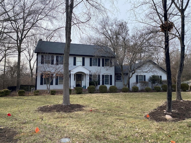 colonial inspired home with a front lawn