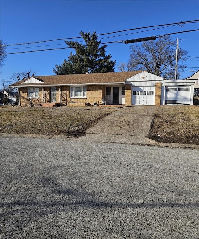 view of front of house featuring an attached garage, driveway, and brick siding