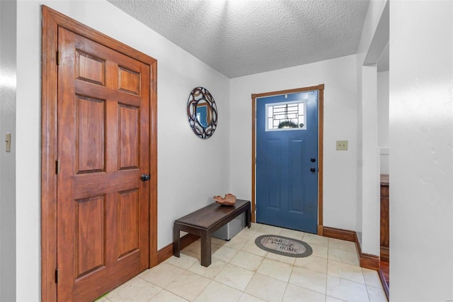 entryway featuring a textured ceiling and baseboards