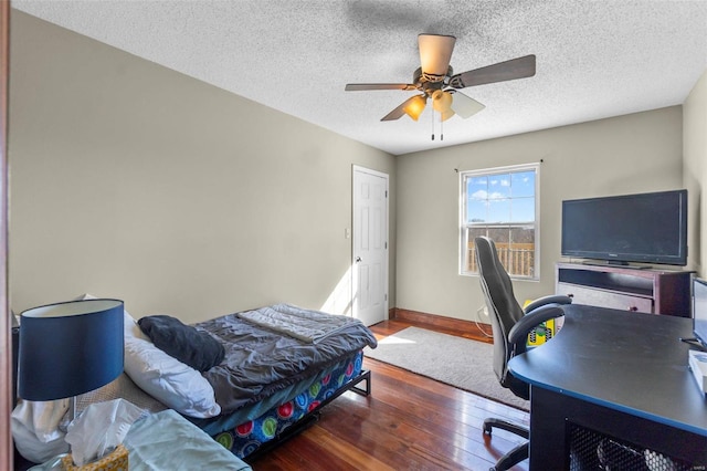 bedroom featuring wood-type flooring, ceiling fan, a textured ceiling, and baseboards