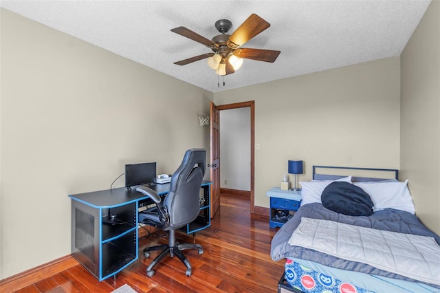 bedroom with ceiling fan, a textured ceiling, baseboards, and wood finished floors