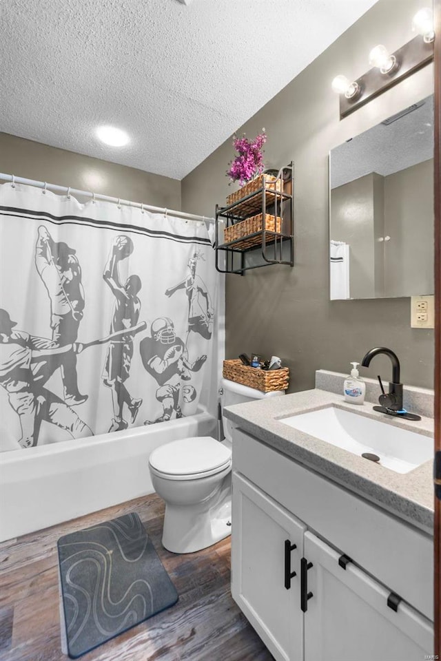 bathroom featuring shower / tub combo, toilet, wood finished floors, a textured ceiling, and vanity