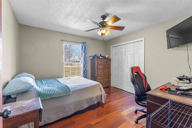 bedroom with ceiling fan, a textured ceiling, a closet, and wood finished floors