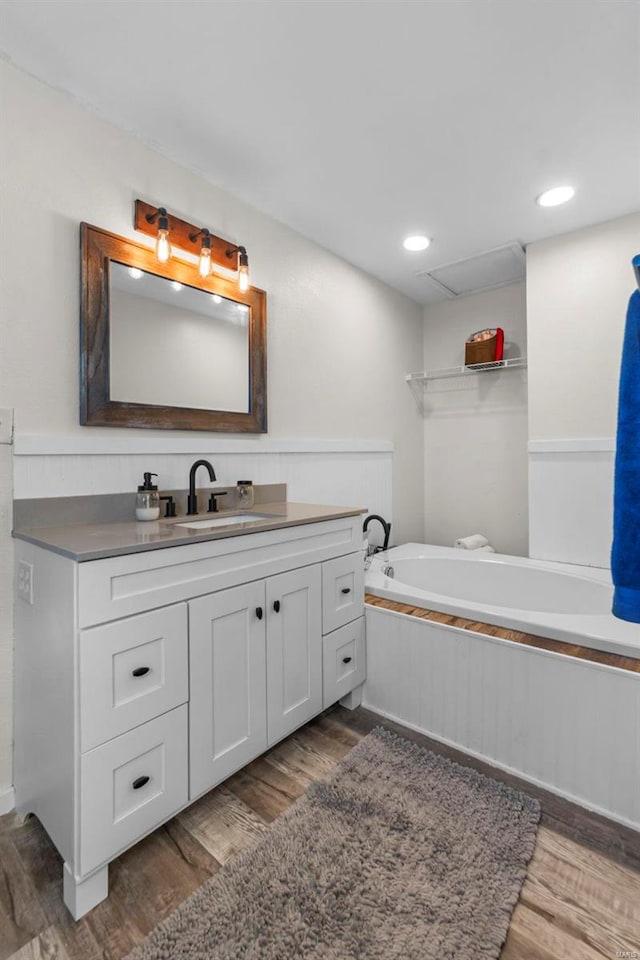 bathroom featuring vanity, wood finished floors, and a washtub