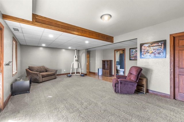 carpeted living area featuring a paneled ceiling, visible vents, baseboards, and recessed lighting