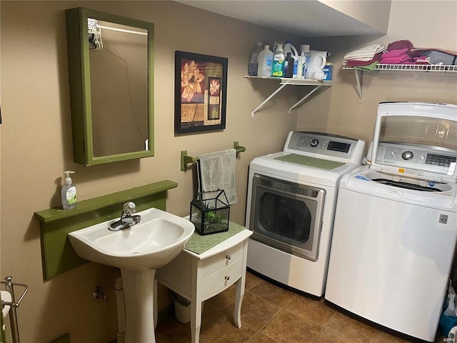 laundry room with dark tile patterned flooring, laundry area, and washer and clothes dryer