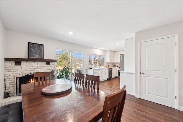 dining area featuring recessed lighting, a brick fireplace, and dark wood-style flooring