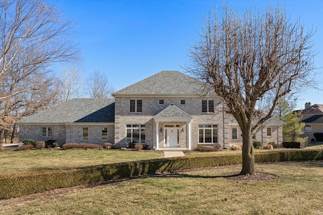 georgian-style home with a front lawn and brick siding