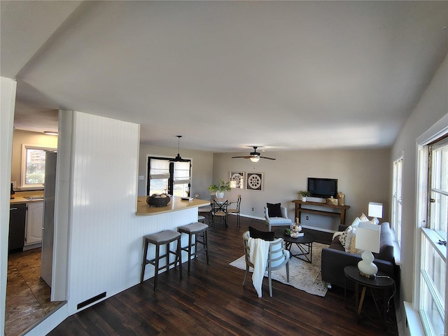 living area with dark wood finished floors and a ceiling fan