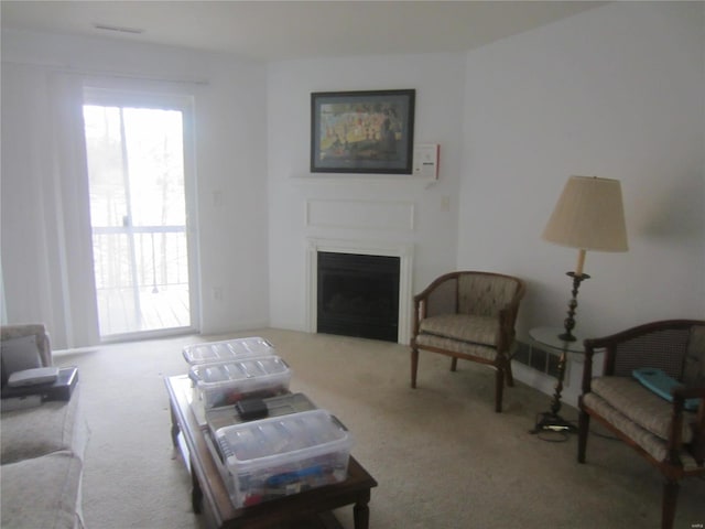 living room with carpet floors and a fireplace