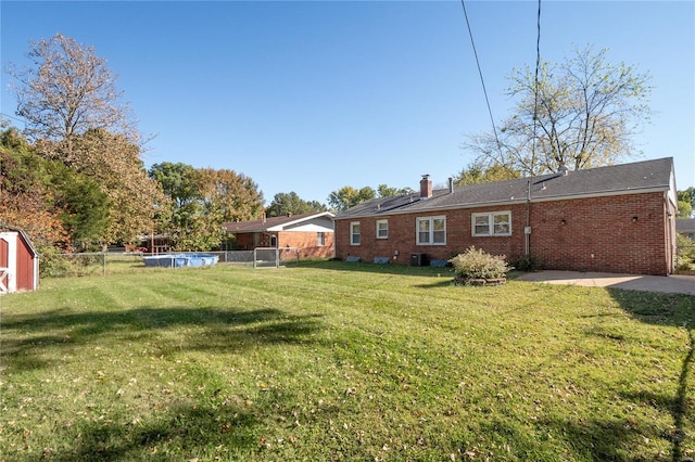 view of yard with an outdoor pool, fence, and central AC unit