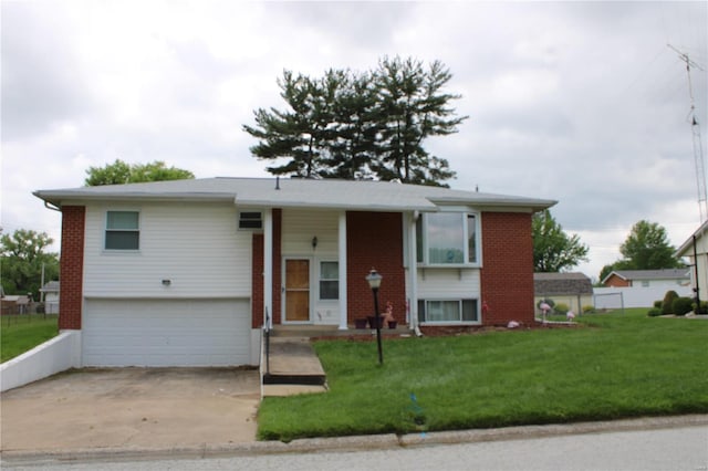 raised ranch featuring a front yard, brick siding, and driveway