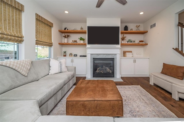 living room featuring ceiling fan, visible vents, a fireplace, wood finished floors, and recessed lighting