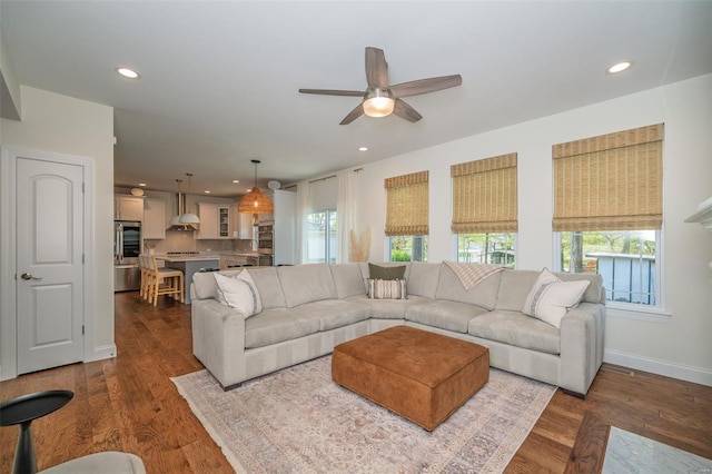 living area with a ceiling fan, baseboards, recessed lighting, and wood finished floors