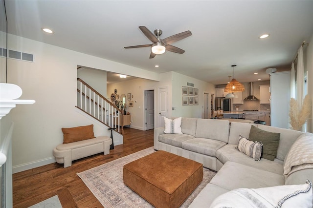 living area featuring baseboards, recessed lighting, and stairs