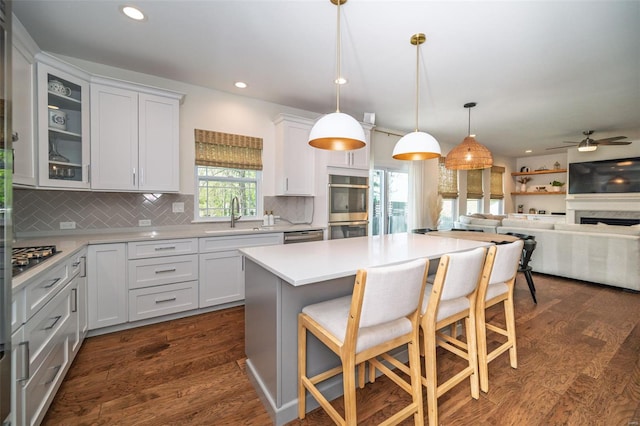 kitchen with stainless steel appliances, recessed lighting, a kitchen bar, backsplash, and a kitchen island