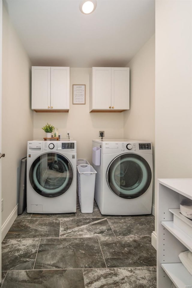 laundry area with baseboards, cabinet space, and washer and dryer