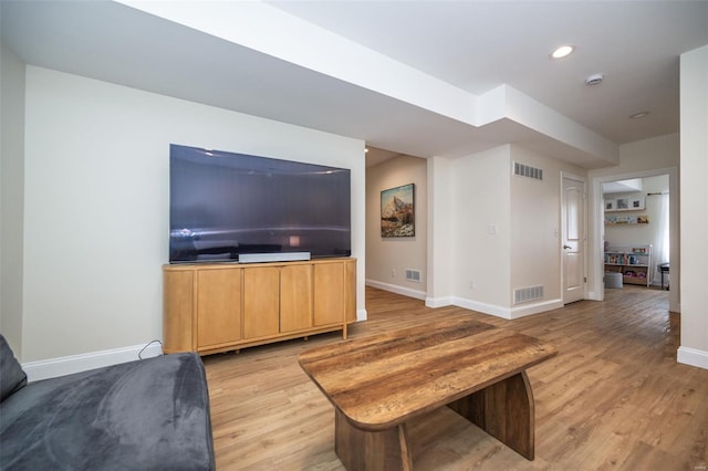 living area featuring baseboards, visible vents, and light wood-style flooring