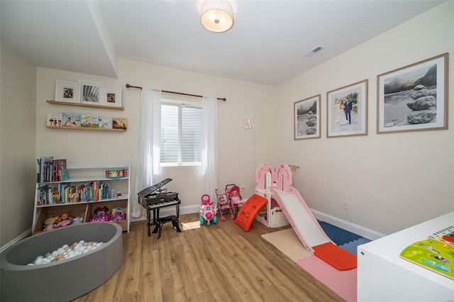 playroom featuring visible vents, baseboards, and wood finished floors