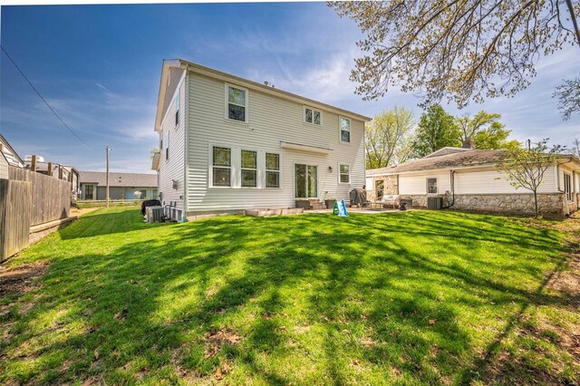 rear view of property with central air condition unit, fence, a yard, a patio, and entry steps