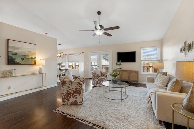 living room featuring french doors, baseboards, wood finished floors, and ceiling fan with notable chandelier