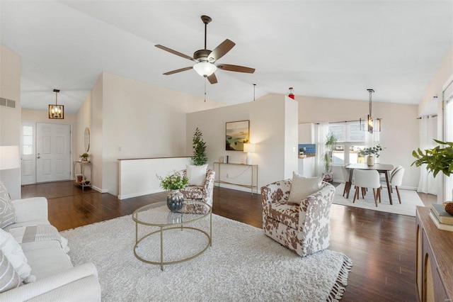 living area featuring visible vents, ceiling fan with notable chandelier, wood finished floors, baseboards, and lofted ceiling