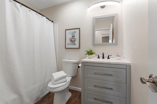 bathroom with toilet, wood finished floors, a shower with shower curtain, baseboards, and vanity