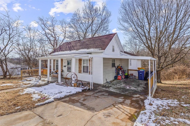 view of front of home with a porch, concrete driveway, and a shingled roof