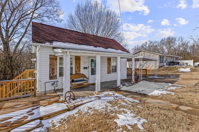 view of front of home featuring a detached carport and roof with shingles