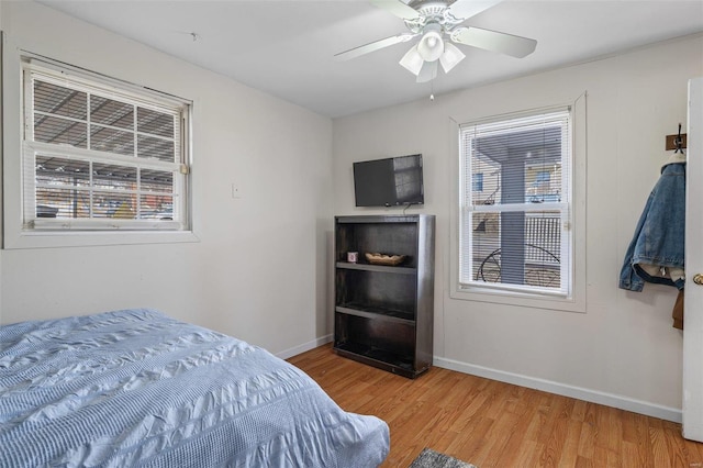 bedroom featuring a ceiling fan, light wood-style flooring, and baseboards