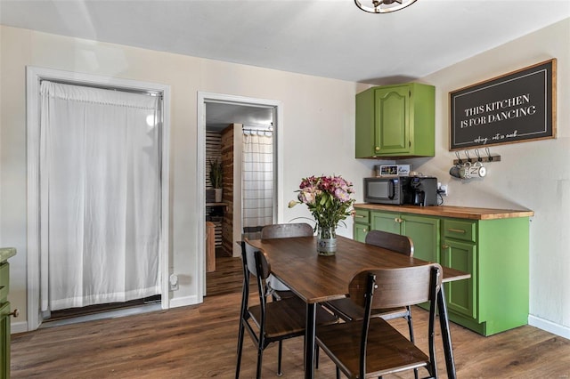 dining room with dark wood-style flooring and baseboards