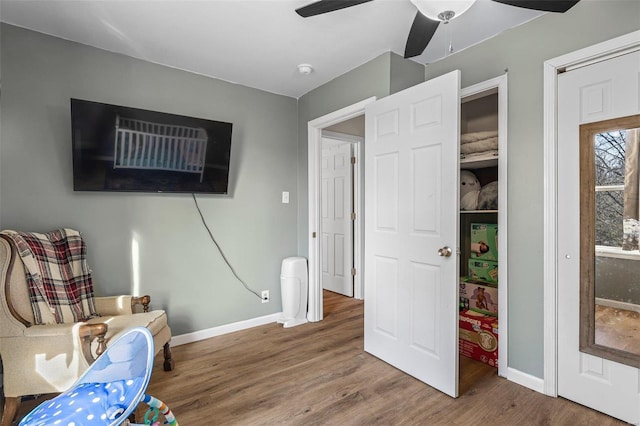 living area with ceiling fan, baseboards, and wood finished floors