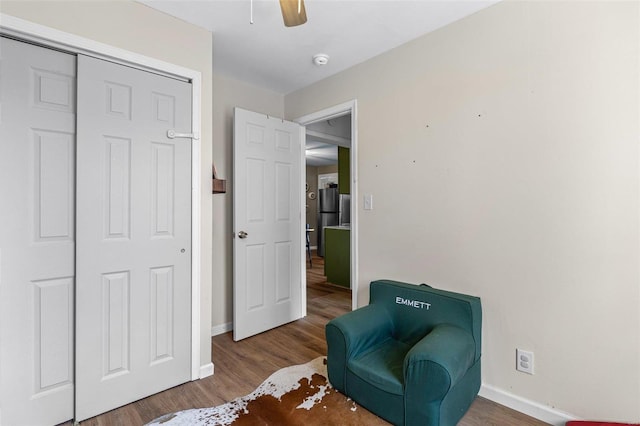 living area with ceiling fan, wood finished floors, and baseboards