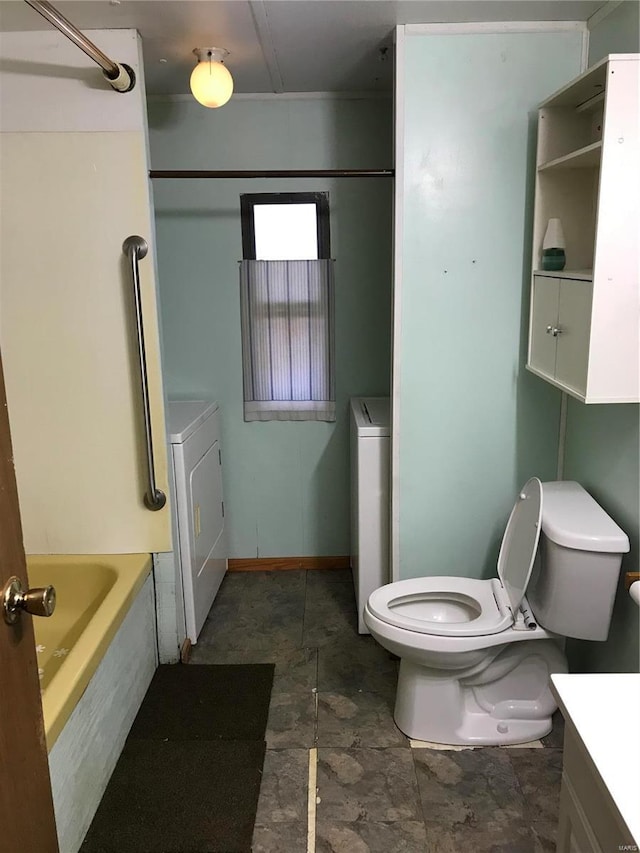 bathroom featuring washer / clothes dryer, baseboards, vanity, and toilet