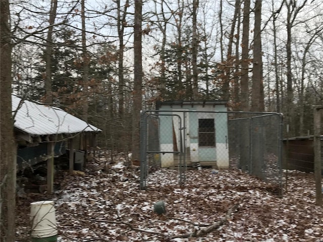 snow covered structure with an outbuilding