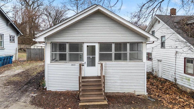 rear view of house with entry steps and fence