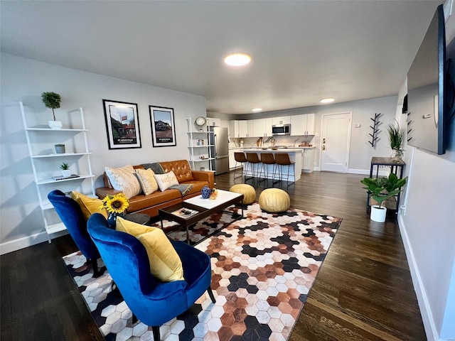 living area featuring baseboards and dark wood-type flooring