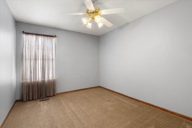 unfurnished room with a textured ceiling, light carpet, a ceiling fan, visible vents, and baseboards