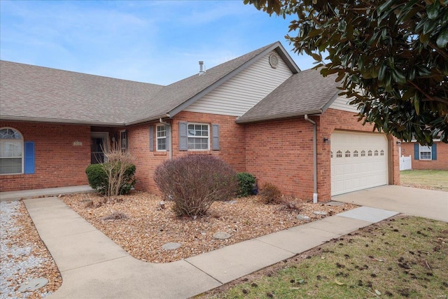 ranch-style home with driveway, brick siding, an attached garage, and a shingled roof