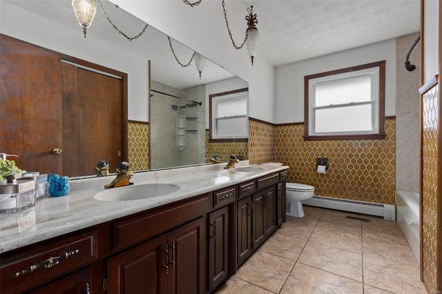 full bath featuring a textured ceiling, a baseboard radiator, tile patterned flooring, toilet, and a sink