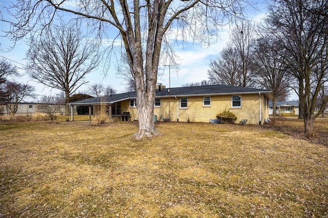 rear view of house featuring crawl space, brick siding, and a yard