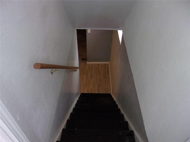 stairs featuring baseboards and wood finished floors