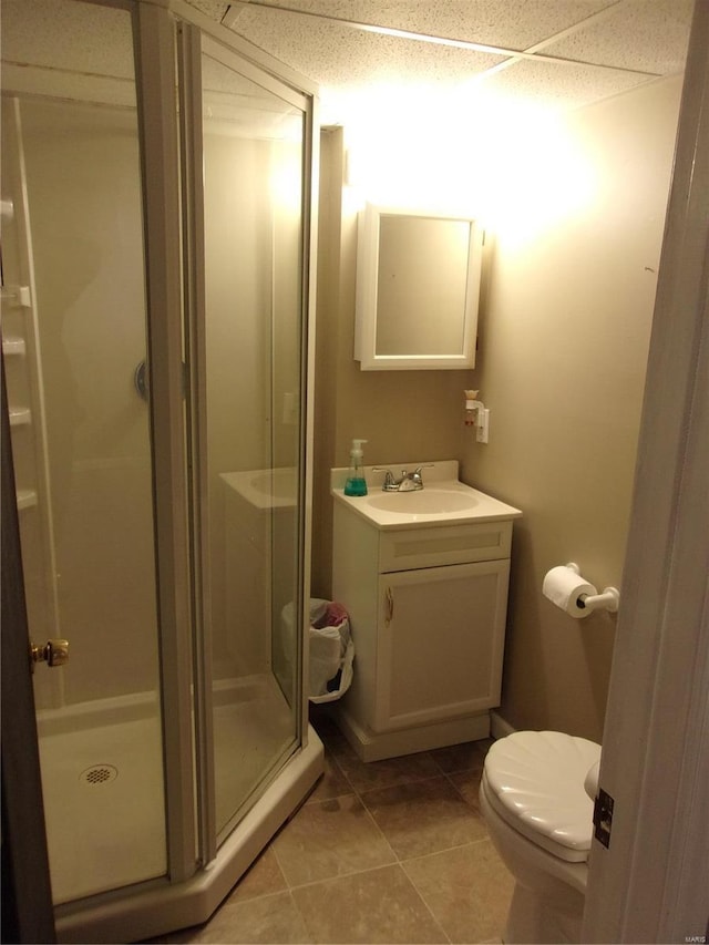 bathroom with tile patterned flooring, a shower stall, toilet, and vanity