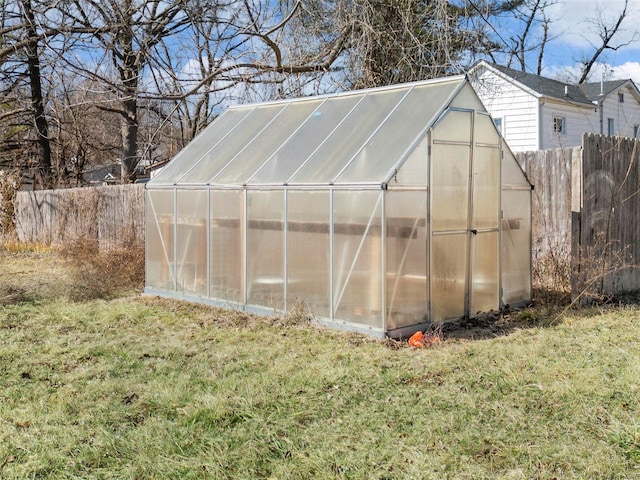 view of greenhouse featuring a yard and fence