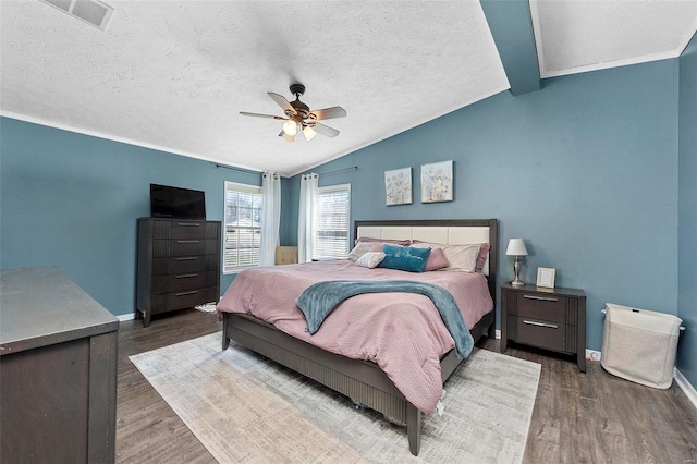 bedroom featuring baseboards, visible vents, vaulted ceiling, and wood finished floors