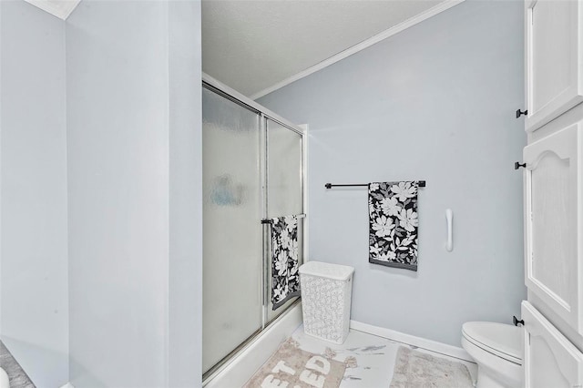 bathroom with ornamental molding, baseboards, a shower stall, and toilet