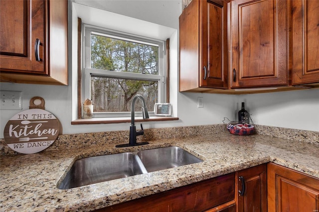 kitchen with light stone counters and a sink