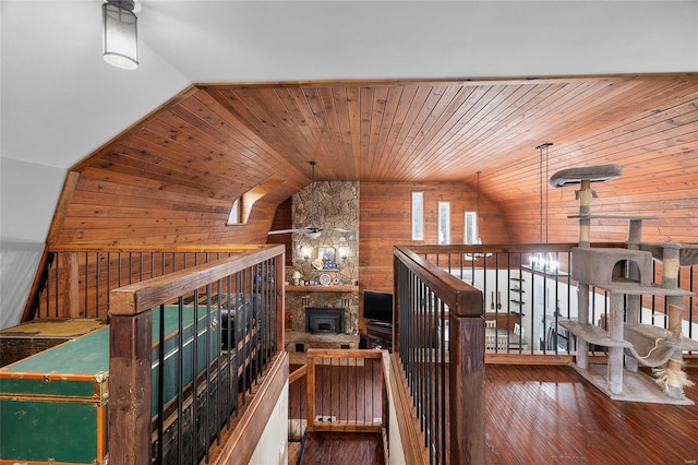 staircase with lofted ceiling, wood-type flooring, wooden ceiling, and wooden walls