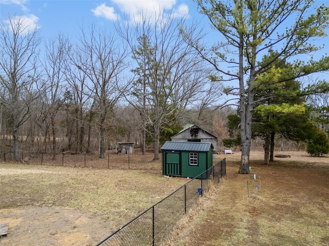 view of yard with an outbuilding, a storage unit, and fence