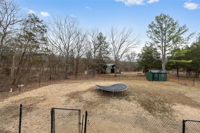 view of yard featuring a gate, fence, an outdoor structure, and a shed